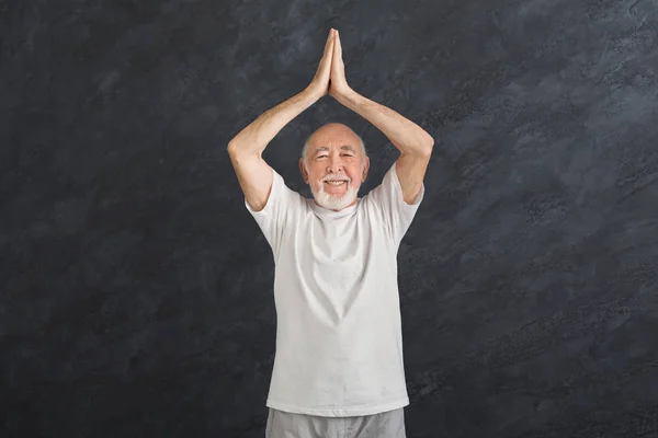Uomo anziano che pratica yoga in piedi a Padmasana — Foto Stock