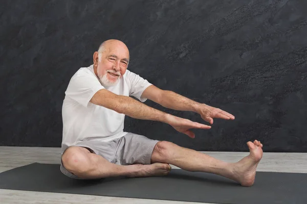 Senior Fitness-Mann dehnt sich drinnen — Stockfoto