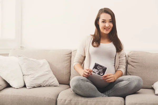 Беременная женщина смотрит на свою детскую сонографию — стоковое фото