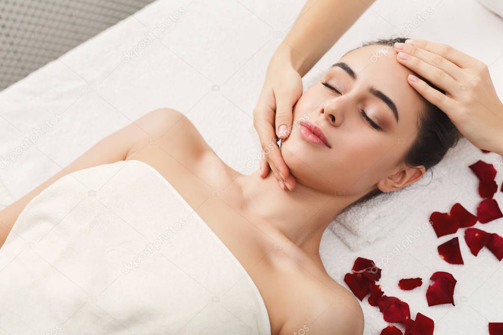 Woman getting professional facial massage at spa