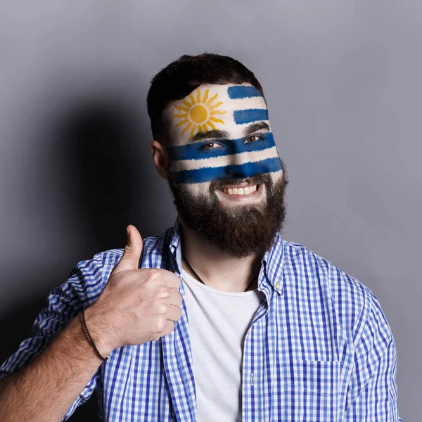 Jovem com bandeira do Uruguai pintada em seu rosto — Fotografia de Stock