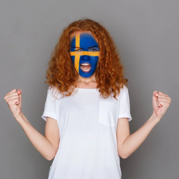 Giovane donna con bandiera svedese dipinta sul viso — Foto Stock