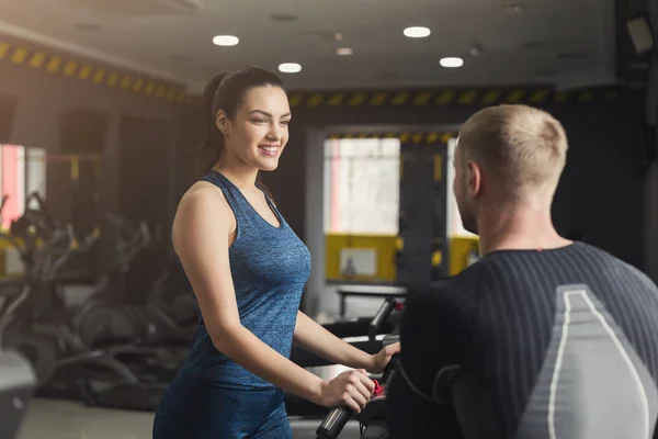 Treinador de fitness ajuda mulher em treinador elíptico — Fotografia de Stock