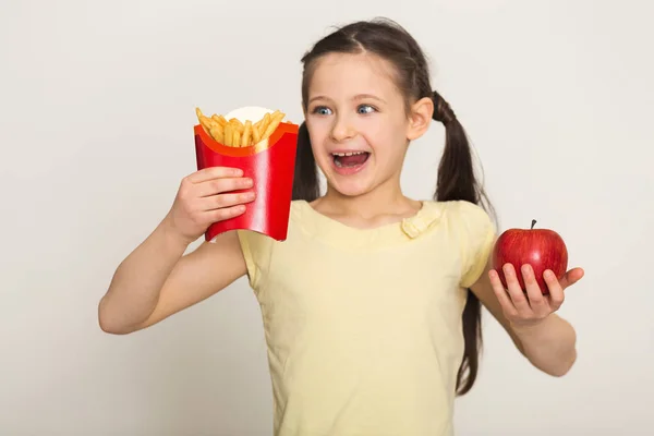 Щаслива маленька дівчинка тримає мішок з картоплею та яблуком — стокове фото
