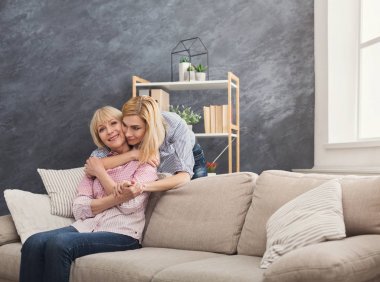 Yetişkin anne ve kızı evde kucaklayan