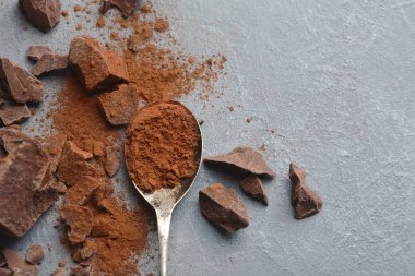 Çikolata parçaları ve gri arka plan üzerine kakao ezilmiş