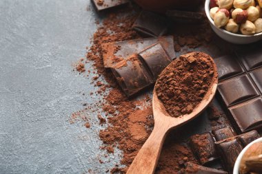 Çikolata parçaları ve gri arka plan üzerine kakao ezilmiş