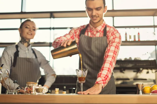 Mannelijke en vrouwelijke barmannen brouwen van verse koffie op café interieur — Stockfoto