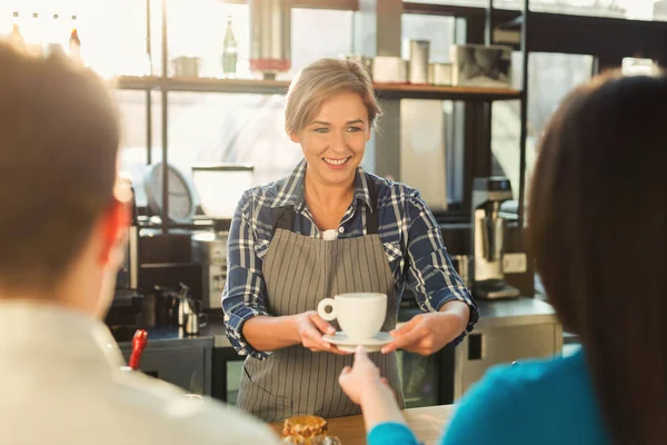 Досвідчений усміхнений бариста робить каву клієнтам — стокове фото