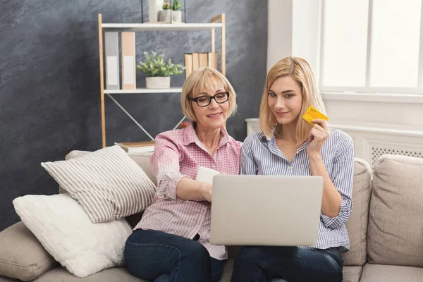 Vuxen kvinna och dotter använder laptop hemma — Stockfoto