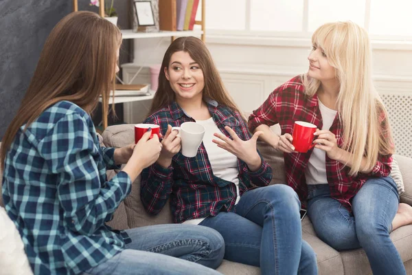 Tre unga kvinnliga vänner med kaffe chatta hemma — Stockfoto