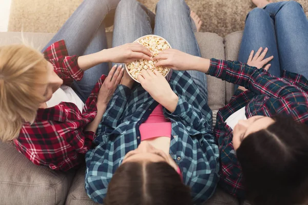 Tři ženy jíst popcorn doma, pohled shora — Stock fotografie