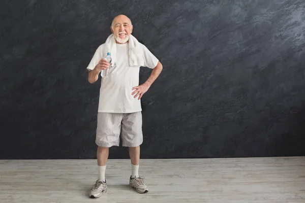 Törstig senior man dricksvatten från flaska — Stockfoto