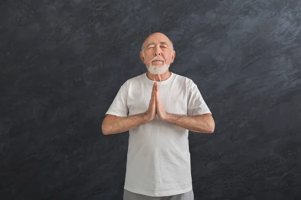 Meditar o homem sênior com as mãos em oração dentro de casa — Fotografia de Stock