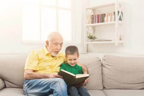 Старший читает книгу для внука — стоковое фото