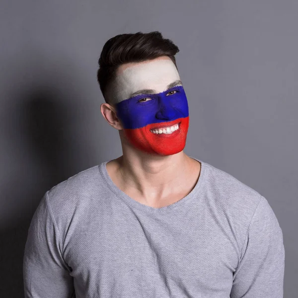 Giovane uomo con bandiera russa dipinta sul viso — Foto Stock