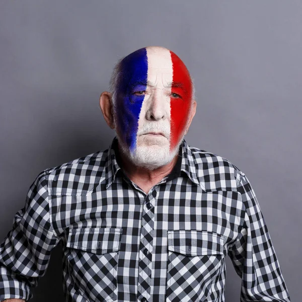 Senior man with France flag painted on his face