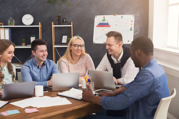 Equipo joven discutiendo proyecto en oficina moderna — Foto de Stock