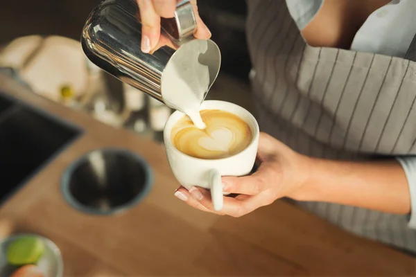 Closeup de barmen derramando leite para copo cappuccino — Fotografia de Stock