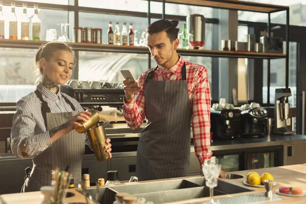 Mannelijke en vrouwelijke barmannen op koffie toonbank — Stockfoto