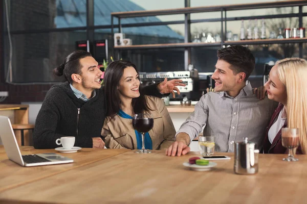 Happy young friends drinking coffee at cafe