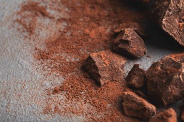 Çikolata parçaları ve gri arka plan üzerine kakao ezilmiş