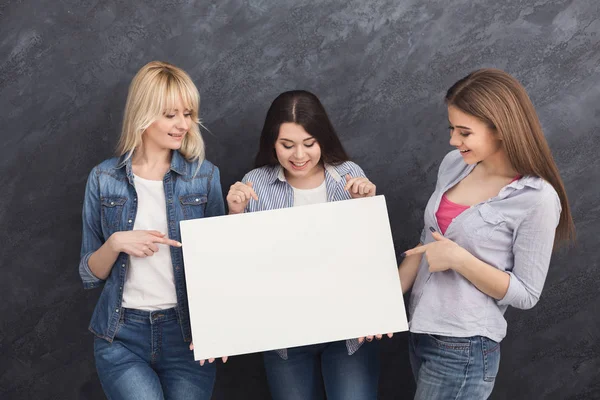 Three girlfriends holding blank white banner — Stock Photo, Image