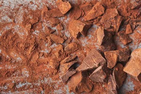 Piezas de chocolate trituradas y cacao sobre fondo gris —  Fotos de Stock