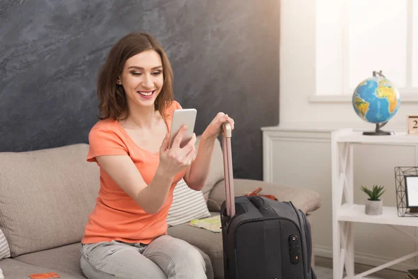 Frau reif für die Reise, sitzt mit Koffer — Stockfoto