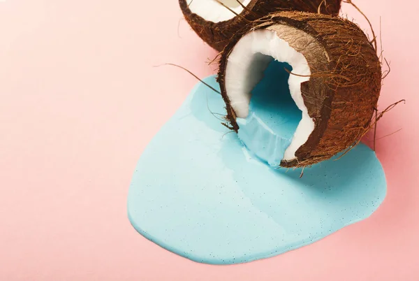 蓝色颜料从椰子上跑出粉红色背景 — 图库照片