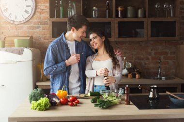 Mutlu çift birlikte yemek pişiriyor.