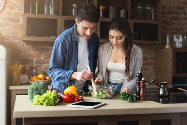 Mutlu çift birlikte yemek pişiriyor.