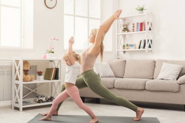 Anne ve küçük kızı birlikte yoga yaparken