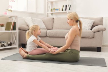 Anne ve küçük kızı birlikte yoga yaparken