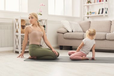 Anne ve küçük kızı birlikte yoga yaparken