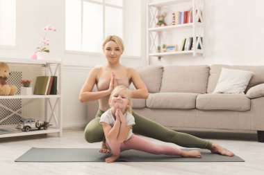 Anne ve küçük kızı birlikte yoga yaparken