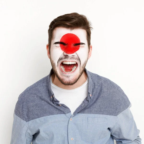 Junger Mann mit japanischer Flagge im Gesicht — Stockfoto