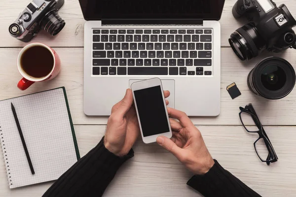 Photographer using smartphone on workplace — Stock Photo, Image