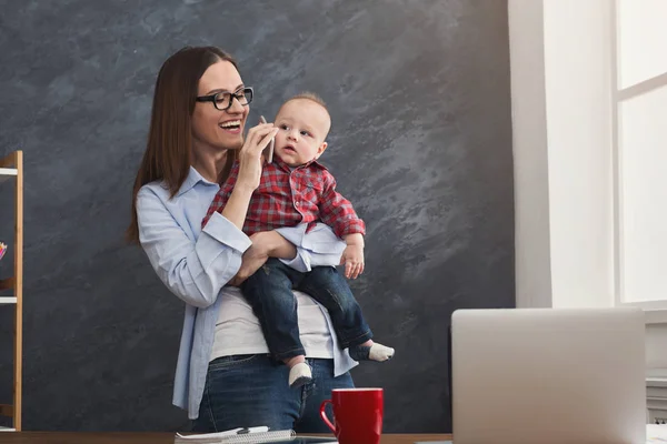 Jeune mère qui travaille et passe du temps avec bébé — Photo