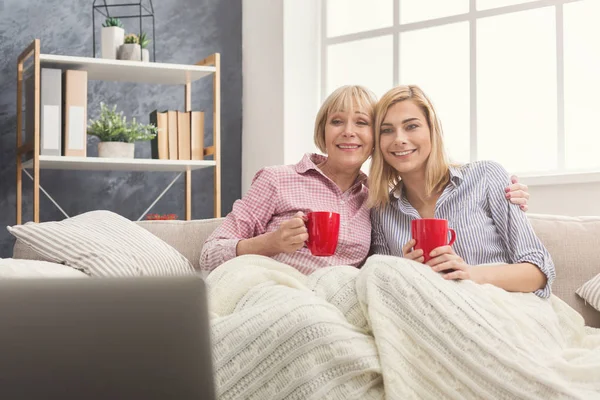 Glada vuxna mor och dotter titta på film hemma. — Stockfoto