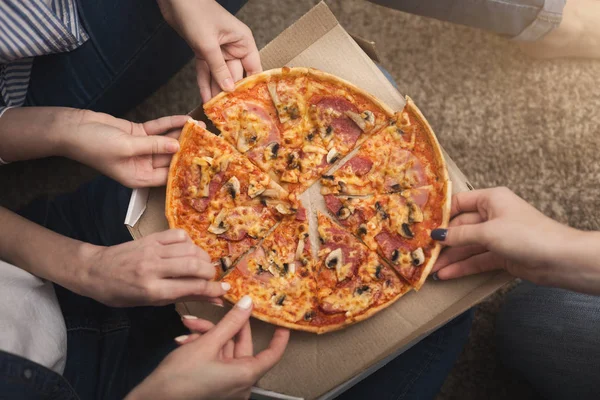 Nahaufnahme von drei Freundinnen beim Pizzaschneiden — Stockfoto