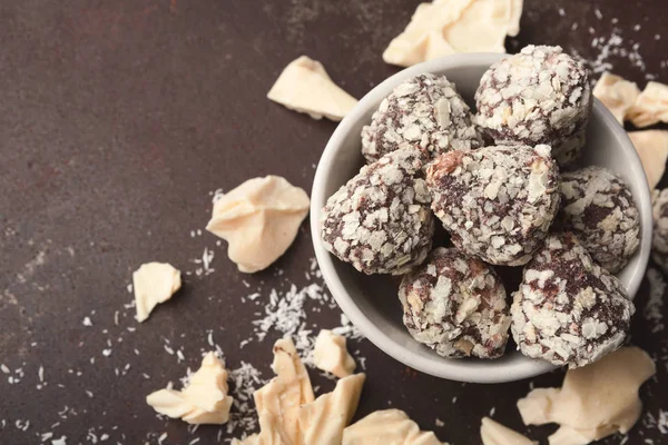 Gemalen witte chocoladestukjes en truffels op grijze achtergrond — Stockfoto