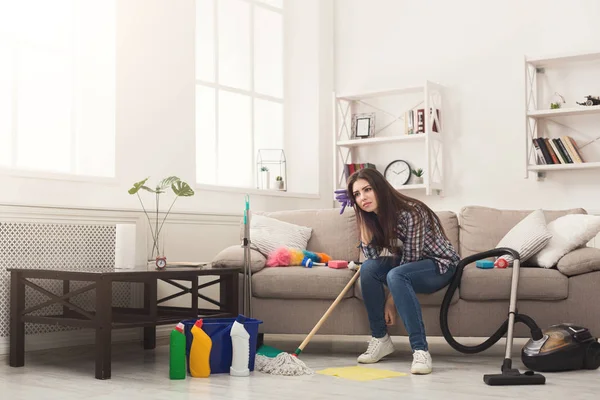 Mujer cansada casa de limpieza con un montón de herramientas — Foto de Stock