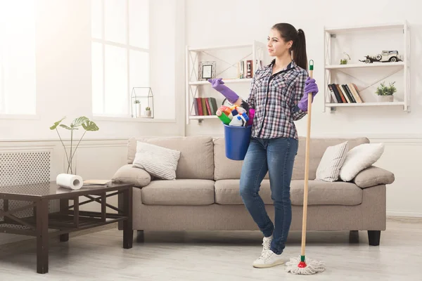 Vrouw met reinigingsapparatuur klaar om de kamer schoon — Stockfoto