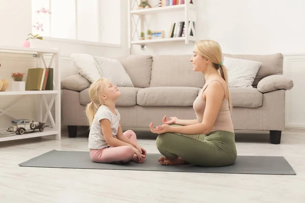 Moeder en dochtertje doen yoga samen — Stockfoto