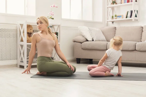 Mother and little daughter doing yoga together — Stock Photo, Image