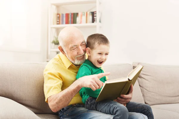 Senior man reading book for his grandchild — Stock Photo, Image