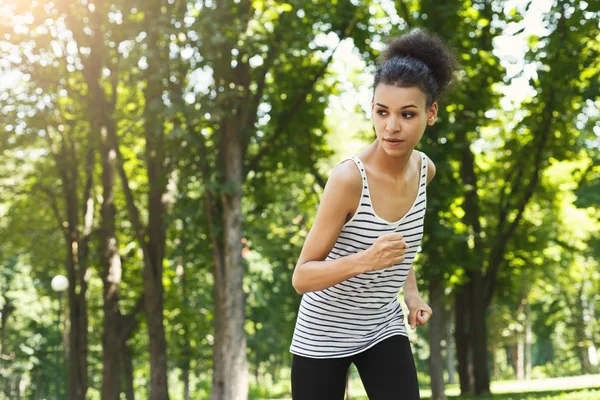 Молодая женщина бегает по зеленому парку, копирует пространство — стоковое фото