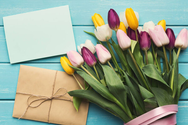 Цветные тюльпаны на синем деревянном фоне, вид сверху
