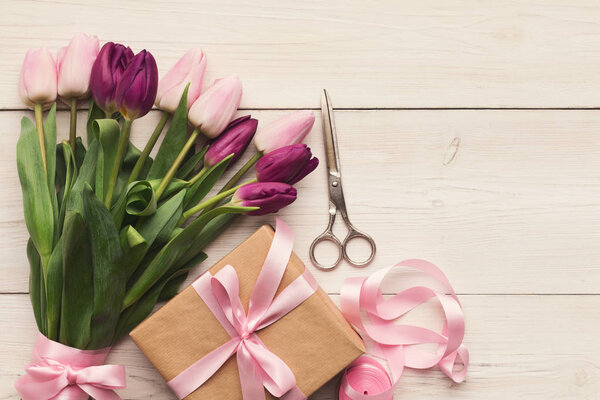 Colorful tulips on white wooden background, top view